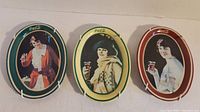 Three oval Coca Cola tin trays displayed side by side showing different vintage women artwork with colored borders.