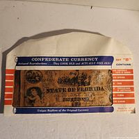 Close-up of the set packaging showing one visible $1 Florida Confederate currency replica and list of other bills in the set.