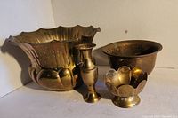 Four copper and brass decorative dishes and items arranged together showing condition and design details