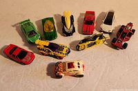 Overview of 10 Hot Wheels toy cars in various colors and designs arranged on a flat surface.