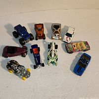 Top view showing all 10 Hot Wheels cars arranged on a table, various colors and styles visible.