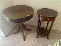 Photo of two round wood veneer tables side by side, showing tops and bases.