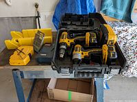 Overview of two DeWalt drills with batteries, charger, bit sets, miter box and case