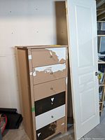 Photo of tall dresser with five drawers showing peeling and chipped paint in various areas.