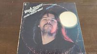 Front cover of the Night Moves vinyl album, featuring a portrait of Bob Seger with long hair and mustache, worn with visible scratches and some edge wear.