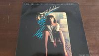 Front cover of the Flashdance soundtrack vinyl with image of woman and title text
