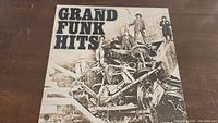 Front cover of Grand Funk Hits vinyl album showing industrial machinery in black and white.