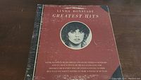 Front cover of Linda Ronstadt Greatest Hits vinyl album showing the red background, artist photo and album title.
