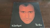 Front cover of the Phil Collins No Jacket Required vinyl album showing close-up photo of the artist's face and title text.