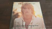 Front cover of Rod Stewart Foot Loose & Fancy Free vinyl record album showing Rod Stewart in a white suit jacket with blurred outdoor background.