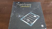 Front cover of Supertramp Crime Of The Century vinyl album showing the iconic abacus hands design and album title in white and yellow text on a black starry background.