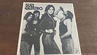 Front cover of Suzi Quatro vinyl LP showing band members in black and white photo.