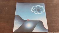 Front cover of The Alan Parsons Project Best Of album showing abstract surreal artwork with clouds and landscape.