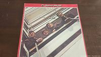 Front cover of The Beatles 1962-1966 vinyl record album showing the band looking from a balcony with a red border around the cover.