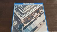 The front cover of the vinyl album 'The Beatles 1967-1970' showing the band looking down from a balcony in a modern building.