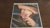 Front cover of The Cars album featuring a woman smiling and holding steering wheel.