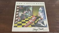 Front cover of The J. Geils Band Freeze Frame vinyl LP album showing colorful artwork with man and abstract shapes.