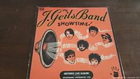 Front cover of the J. Geils Band Showtime vinyl record showing album art with caricatures and horn speaker image, title and album description.