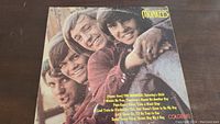 Front cover of The Monkees vinyl record album showing band members and track listing.