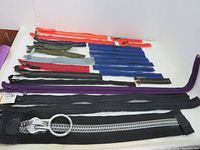 Photo showing 24 zippers laid out, colors include orange, dark green, red, blue, purple, black, with some featuring brass teeth and others plastic.