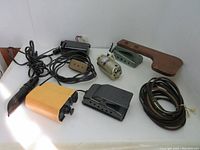 Photo showing entire lot including motors, belts, control panel with wood attachment, foot pedal controller, yellow speed control box, and Singer sewing machine light.