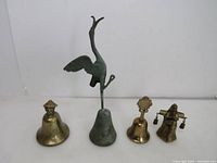 Front view of all four brass bells showing size variation and design details.