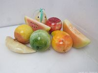 Front view of all eight carved marble fruit pieces grouped together.