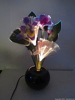 Front view of the vintage fiber optic lamp glowing with colorful illuminated flowers and fiber optic strands.