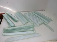 Lot of vintage glass panels arranged on a white surface, showing multiple stacks of panels with rounded edges and white center stripes.