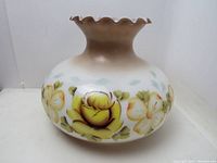 Front and side views of vintage glass lampshade showing floral pattern and ruffled top edge.