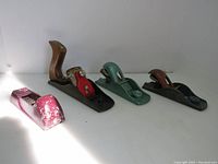 Four vintage wood working tools displayed: three wood planes and one Stanley Sureform tool, showing size and condition.