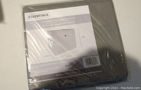 Single unopened grey and black collapsible storage container in plastic packaging with label showing dimensions and product details.