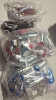 Photo showing unopened sealed plastic bags with red and blue arcade buttons, wiring, and metal joystick shafts for 2 players arcade controller.