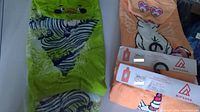 Green kids beach hoodie with playful zebra wrap and frog face design, laid flat to show front.