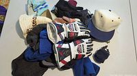 Overview of hats, various gloves, and the pair of L Auclair ski racing gloves visible on table