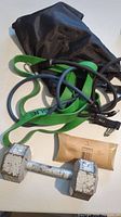 Photo of metal dumbbell with resistance bands and black carrying bag