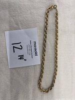 Full view of the twisted rope gold plated necklace choker laid flat showing the length and style.