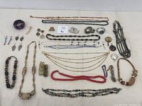 Overview photo of the assorted custom jewelry spread including necklaces, bracelets, earrings, and brooches in various materials and colors.