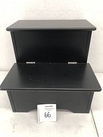 Front view of black wooden dog step stool with the top compartment open, showing the upper storage space and lower drawer closed.