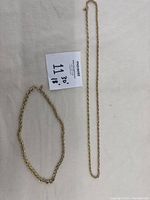 Photo showing entire set of two gold plated necklaces on white background with sizing note