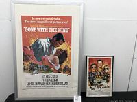 Photo of large framed 'Gone with the Wind' movie poster and smaller 'Once Upon a Time in Hollywood' poster side by side.
