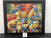 Framed abstract obstruct painting showing geometric shapes and vibrant colors with a black frame. Image includes dimension tag showing 27 1/2 x 23 1/2 inches.