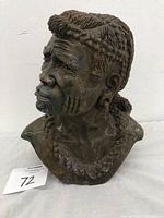 Front-facing close-up of Shona stone bust sculpture showing detailed facial features and braided hair.