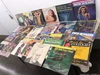 Photo showing front cover artwork of assorted vinyl records arranged in rows on a table, highlighting album art and artist names.