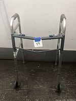 Front view of the aluminum walker showing hand brakes and rubber grips on the handles.