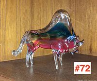 Art glass bull figurine on wooden shelf with multicolor interior glass accents, shown with minor loss to horn tips.