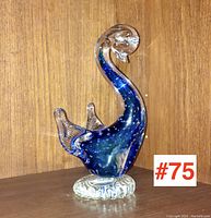 Art glass duck with curved neck and textured base on wooden surface, showing front view