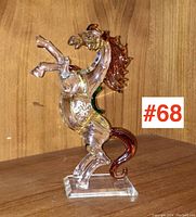 Front angled view of the clear glass horse figurine with brown mane and tail and gold accents.