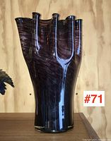 Tall, multiple-finger opening purple art glass vase with swirl design on wooden background