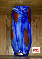 Tall art glass vase showing front blue and red swirl pattern with gold base band